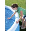 Person legt Solarplane auf einen Pool.
