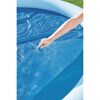 Person deckt einen Pool mit einer blauen Solarplane ab.