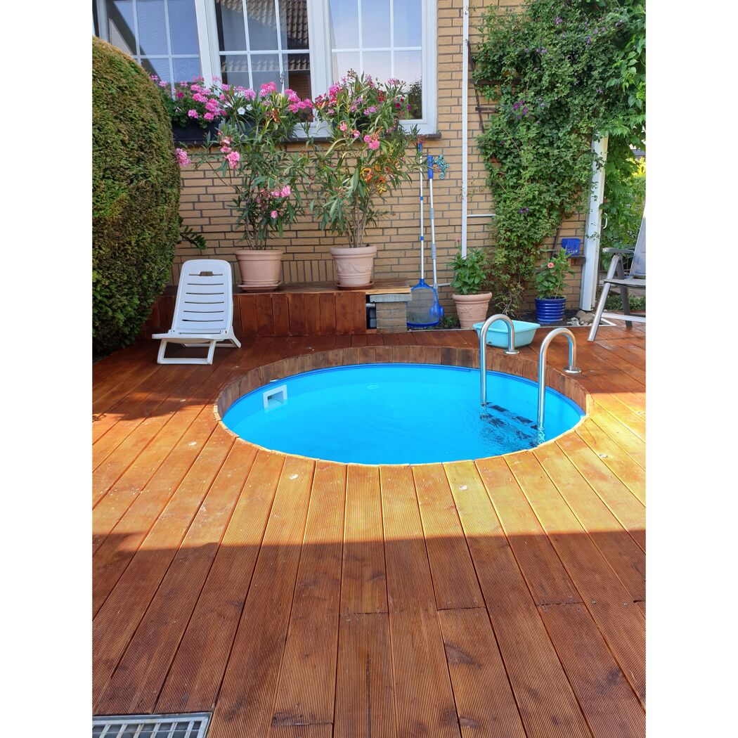 Rundes, blaues Schwimmbecken auf einer Holzterrasse im Garten
