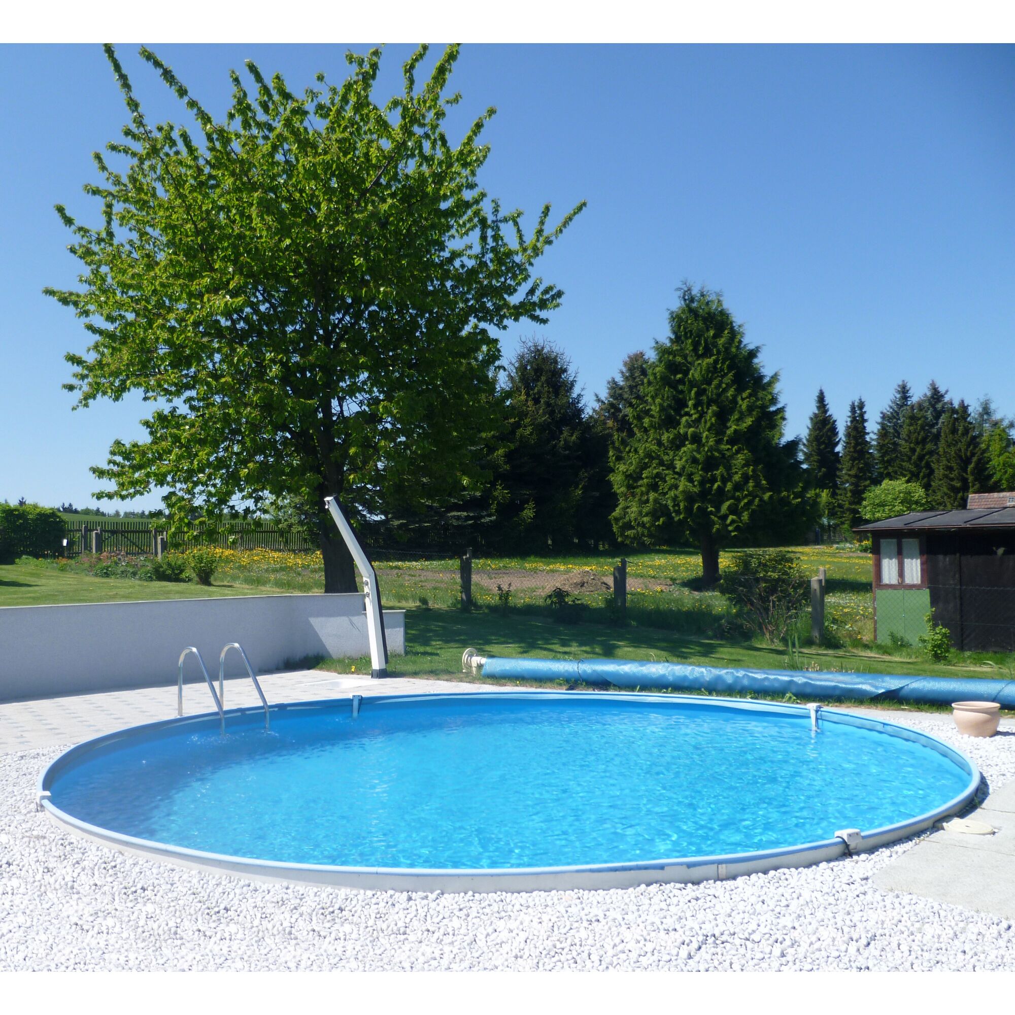 Aufstellpool im Garten mit Kies und Bäumen