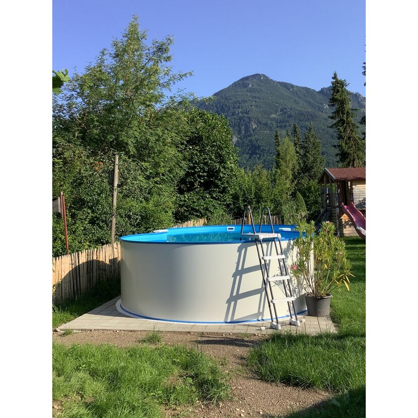 Aufstellpool im Garten mit Leiter und Bergen im Hintergrund