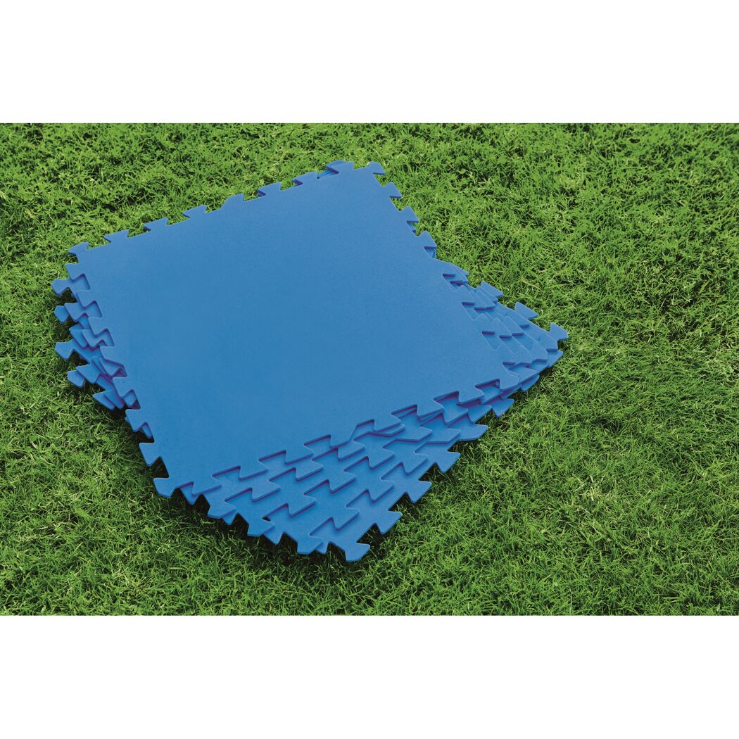 Blaue Bodenschutzmatten auf grünem Rasen.