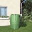 Grüne Regentonne neben einem Haus