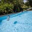 Kescher an Teleskopstange reinigt einen Pool