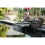 Wasserfall fliesst in einen Gartenteich.