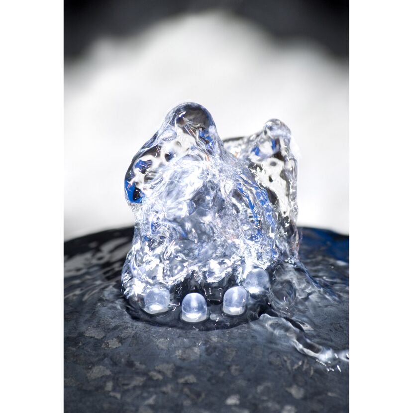 Wasser spritzt aus einem Brunnen.
