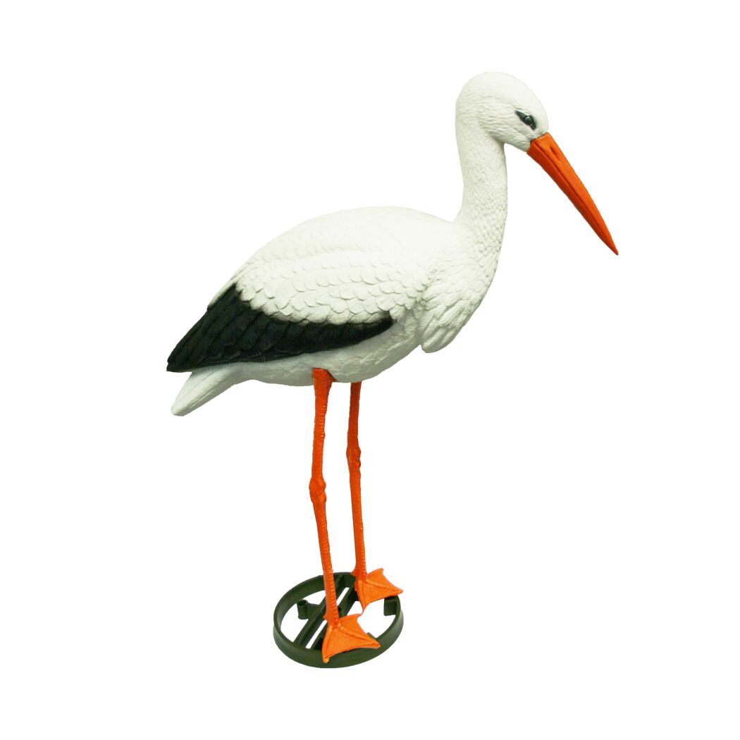 Weißer Deko-Storch mit schwarzem Flügel und orangefarbenen Beinen und Schnabel steht auf einem grünen Erdspieß.