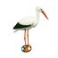 Weißer Deko-Storch mit schwarzem Flügel und orangefarbenen Beinen und Schnabel steht auf einem grünen Erdspieß.