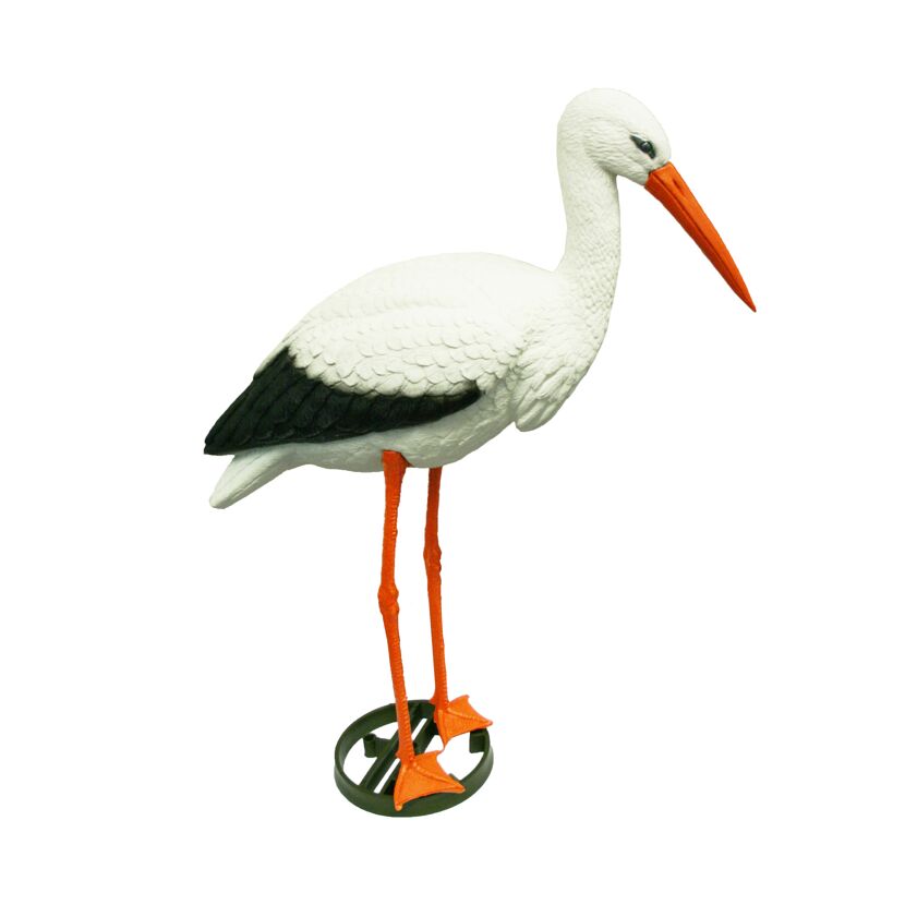 Weißer Deko-Storch mit schwarzem Flügel und orangefarbenen Beinen und Schnabel steht auf einem grünen Erdspieß.