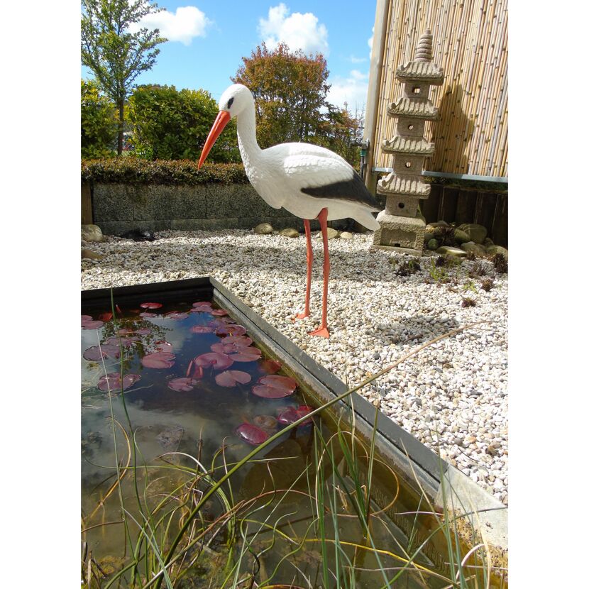 Storch neben Teich und Pagode