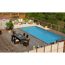 Pool auf einer Holzterrasse mit Gartenmöbeln.
