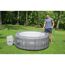 Person füllt einen Lay-Z-Spa Whirlpool mit einem Gartenschlauch.