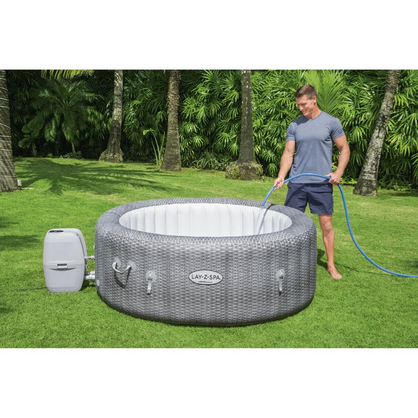 Person füllt einen Lay-Z-Spa Whirlpool mit einem Gartenschlauch.