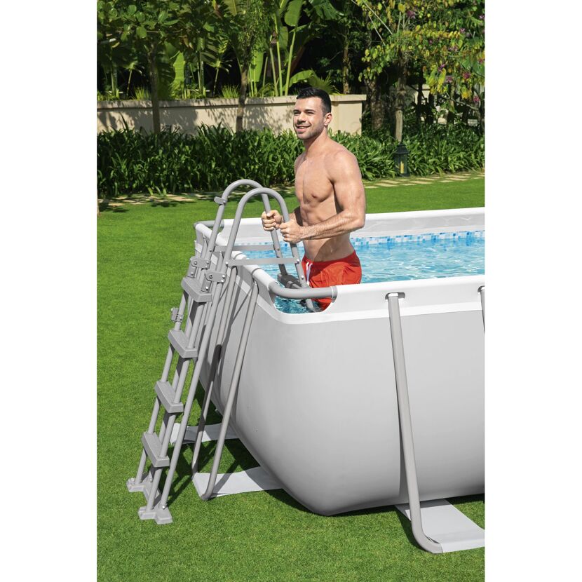 Person steigt über Sicherheitsleiter in Pool