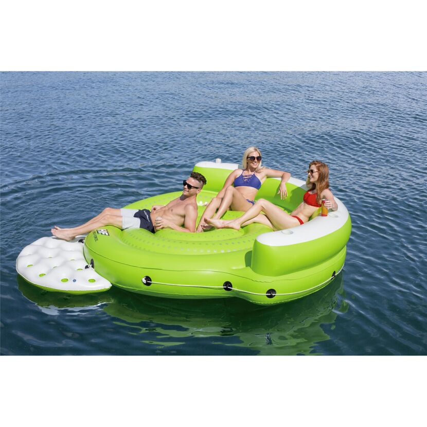 Drei Personen entspannen auf einer aufblasbaren, grünen Lounge im Wasser.