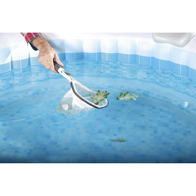 Person entfernt Blätter aus einem Whirlpool mit einem Kescher.