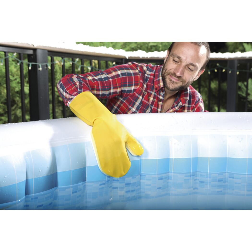 Person reinigt einen aufblasbaren Whirlpool mit einem Schwamm.