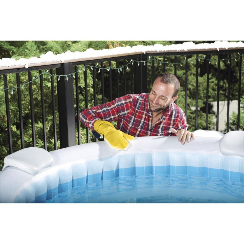 Person reinigt einen Whirlpool mit einem Schwamm.