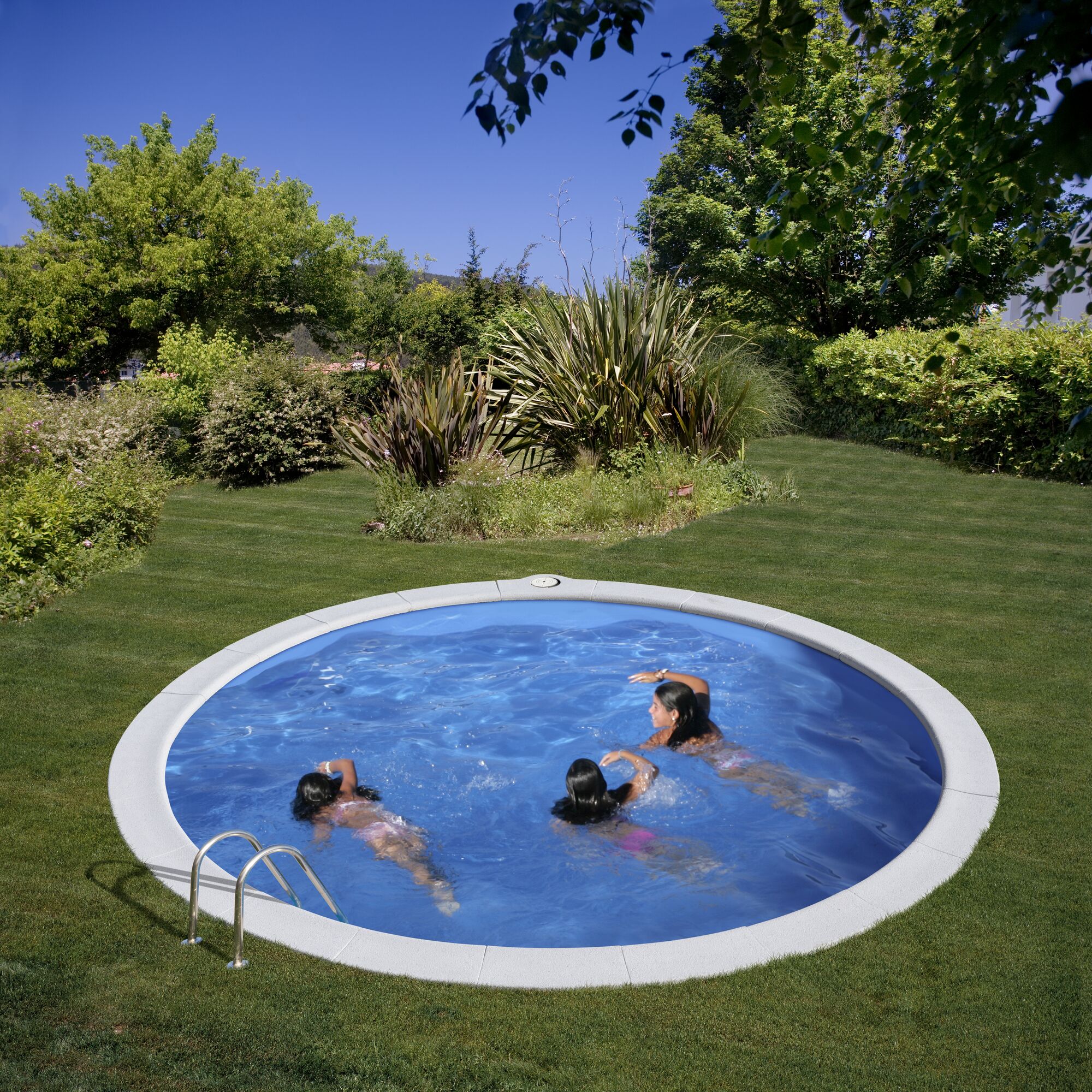 Drei Personen schwimmen in einem runden Pool im Garten.