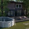 Ovaler Pool mit Holzverkleidung im Garten
