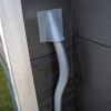 Grauer Wellschlauch an Hauswand
