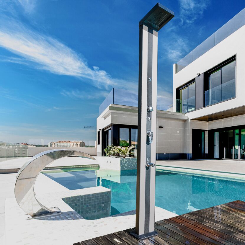 Pool mit Außendusche und Gebäude im Hintergrund