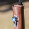Nahaufnahme von einer Solardusche aus Holzoptik mit Wassertropfen.
