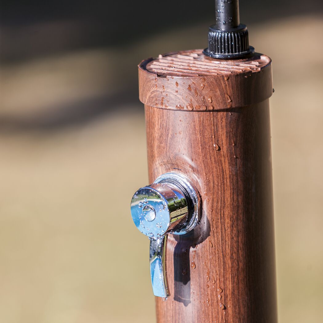 Nahaufnahme von einer Solardusche aus Holzoptik mit Wassertropfen.