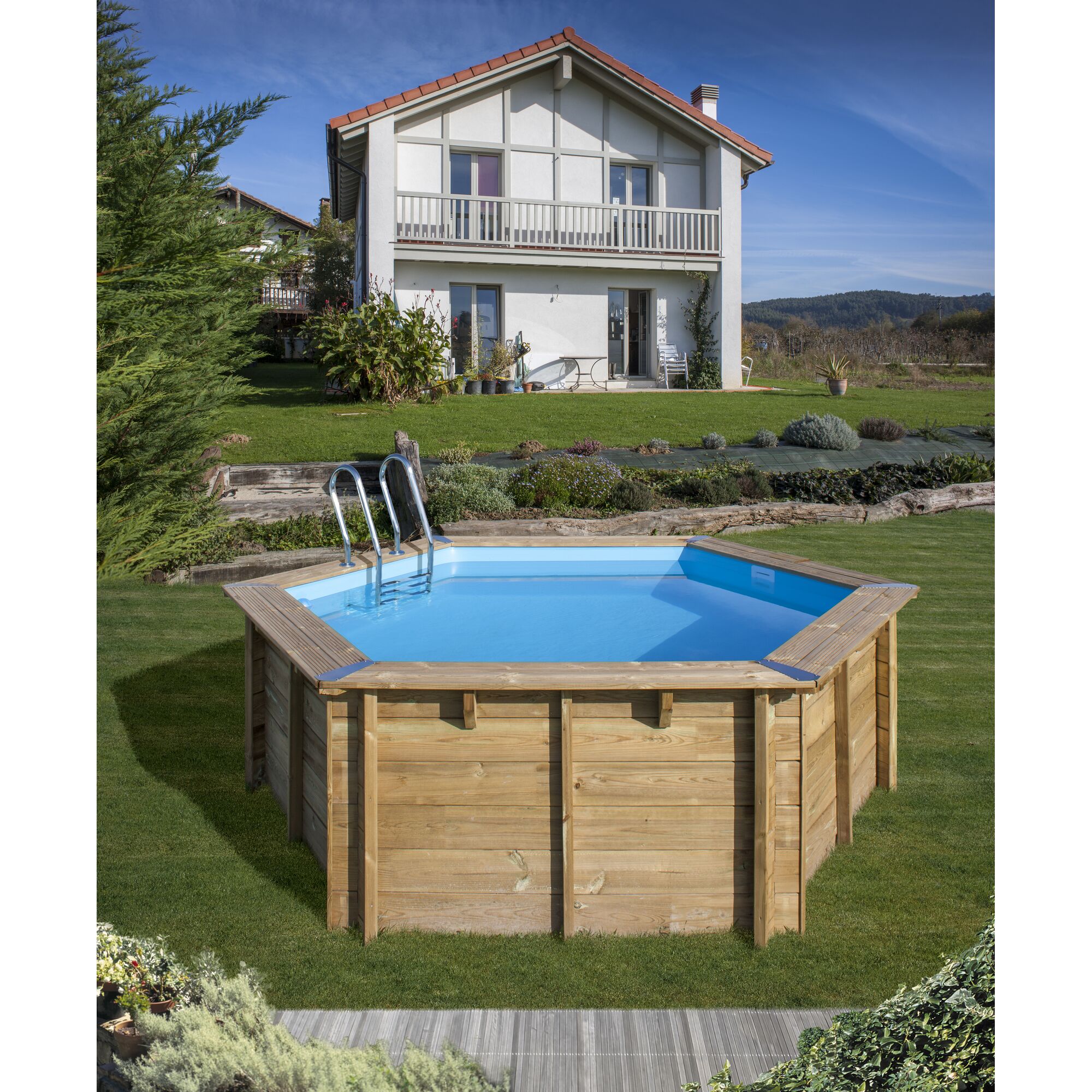 Sechseckiger Holzpool mit blauer Innenfolie und Leiter im Garten.