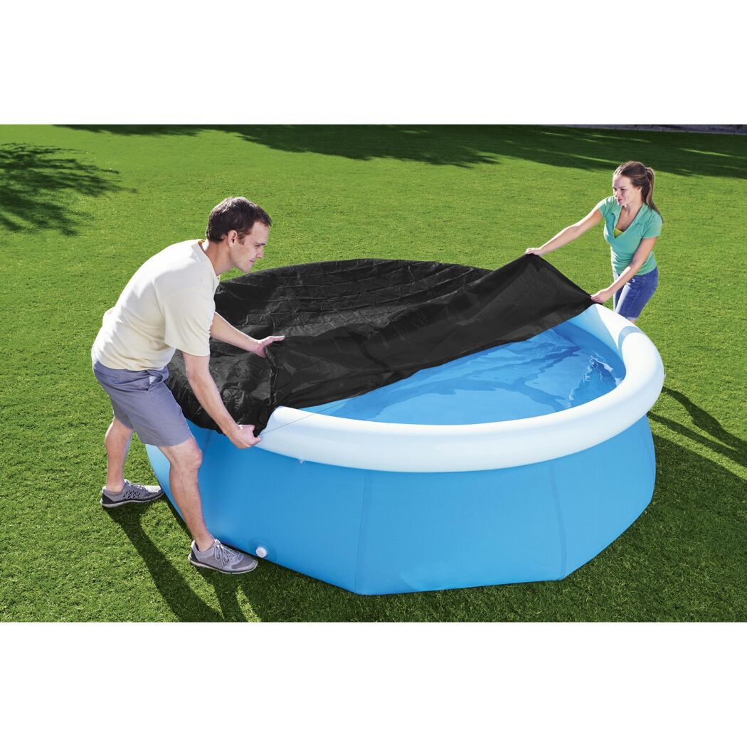 Zwei Personen decken einen aufblasbaren Pool mit einer schwarzen Plane ab.