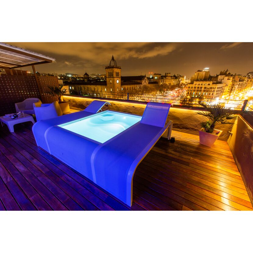 Pool auf Dachterrasse mit Blick auf die Stadt bei Nacht