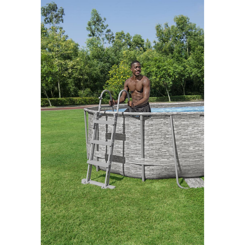 Person steigt über eine Leiter in einen ovalen Aufstellpool.