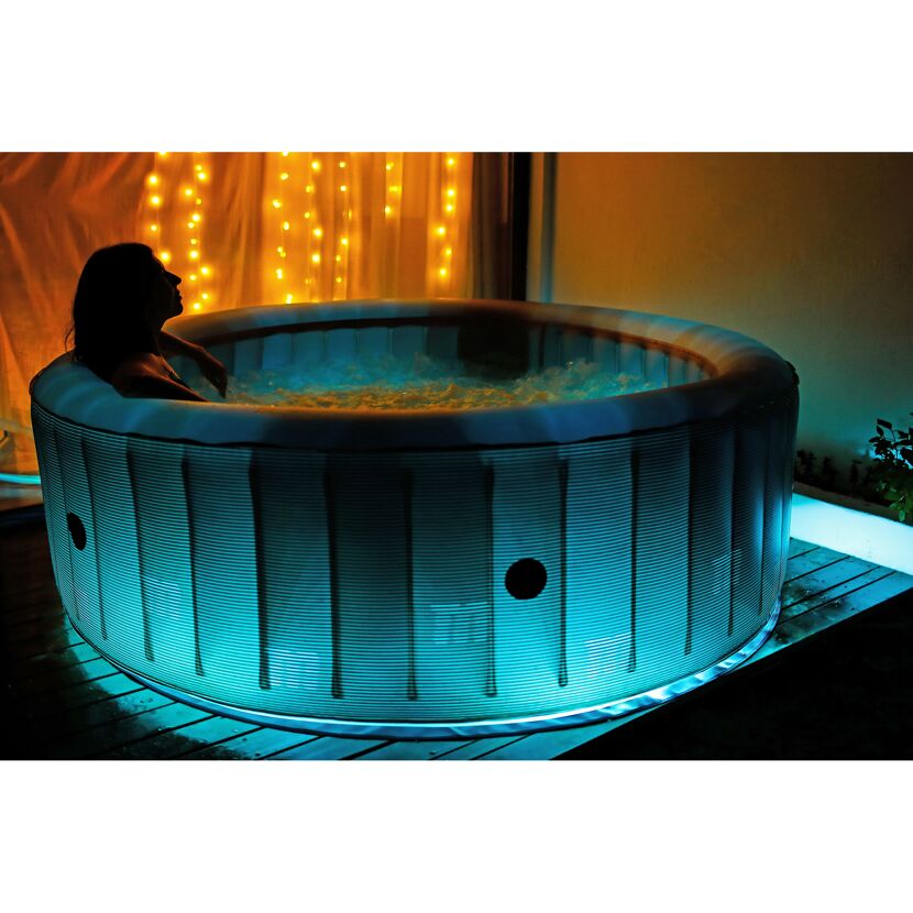 Person entspannt im Whirlpool mit Beleuchtung