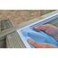 Person befestigt blaue Poolfolie an Holzrahmen