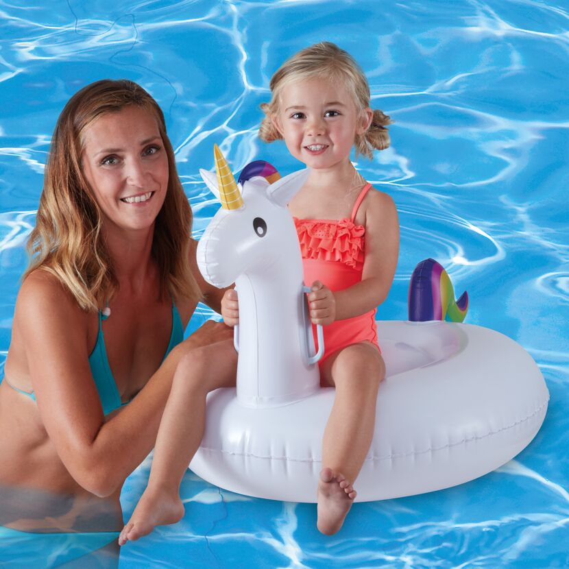 Kind sitzt auf Einhorn Schwimmring im Pool