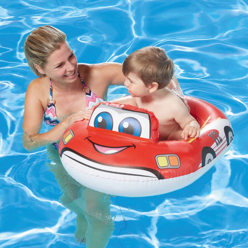 Kind im aufblasbaren Feuerwehrauto im Pool