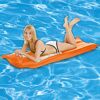 Person liegt auf einer orangen Luftmatratze im Pool