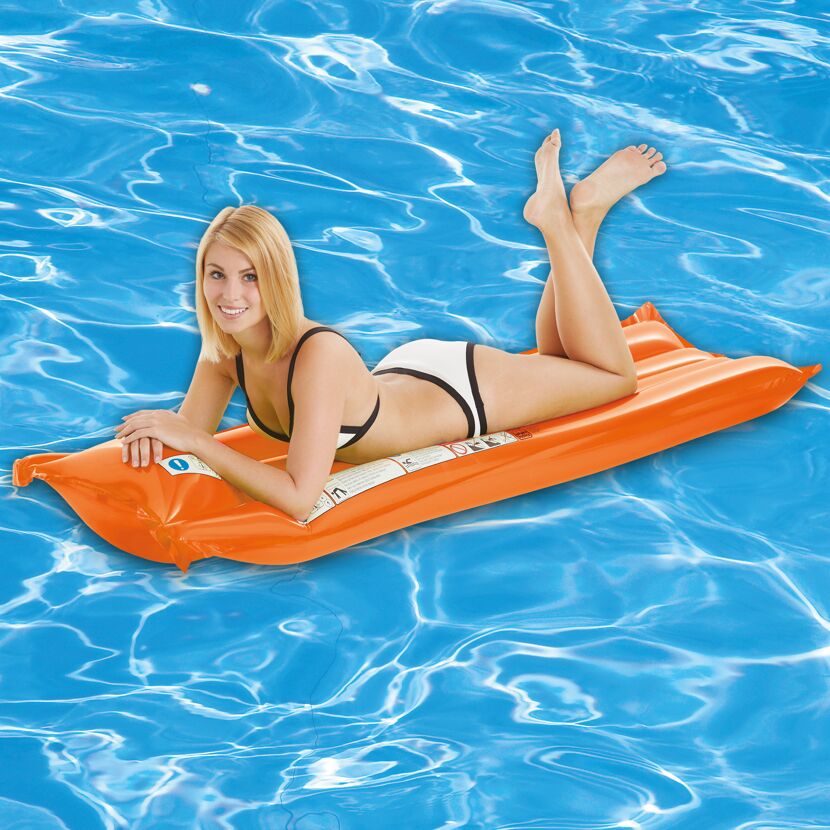 Person liegt auf einer orangen Luftmatratze im Pool