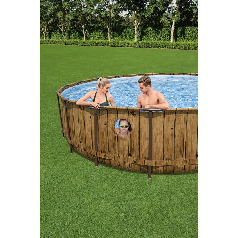 Drei Personen in einem runden Aufstellpool mit Holzoptik.