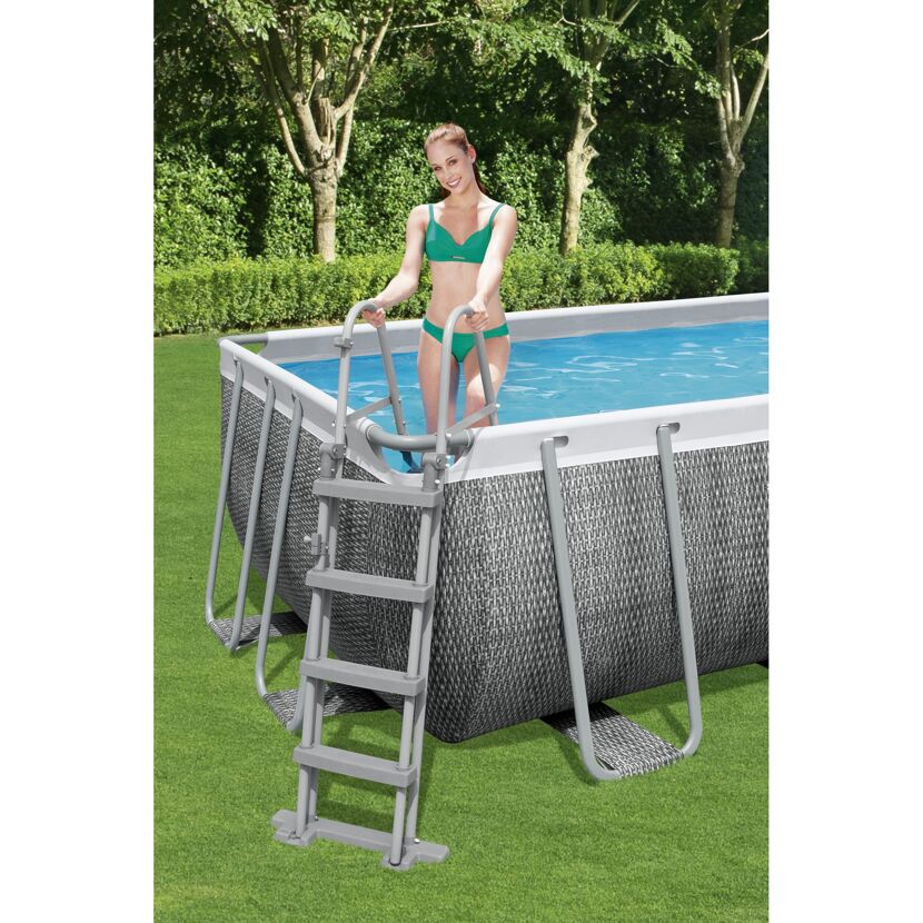 Person steigt über eine Leiter in einen rechteckigen Pool.