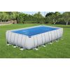 Rechteckiger Pool mit blauer Solarfolie auf Rasen