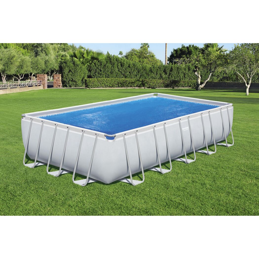 Rechteckiger Pool mit blauer Solarfolie auf Rasen