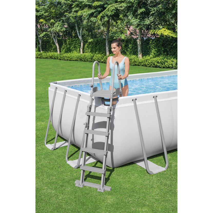 Person steigt über Poolleiter in einen Aufstellpool.