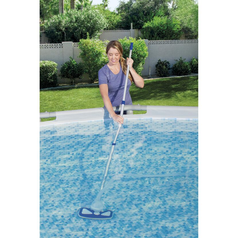 Person reinigt einen Pool mit einem Kescher.
