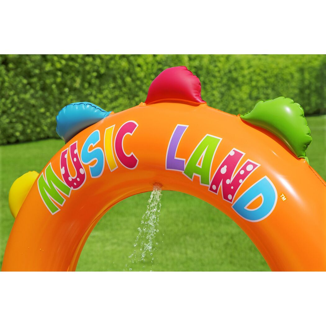 Orangefarbenes, aufblasbares Wasserspielcenter mit bunten Punkten und der Aufschrift "MUSIC LAND". Wasser spritzt aus dem Bogen.