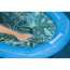 Hand auf einer blauen Bestway Poolmatte mit grünem Blattmuster