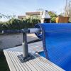 Blaue Poolabdeckung aufgerollt an einem Aufroller.