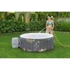 Person füllt einen Lay-Z-Spa Whirlpool mit einem Gartenschlauch.