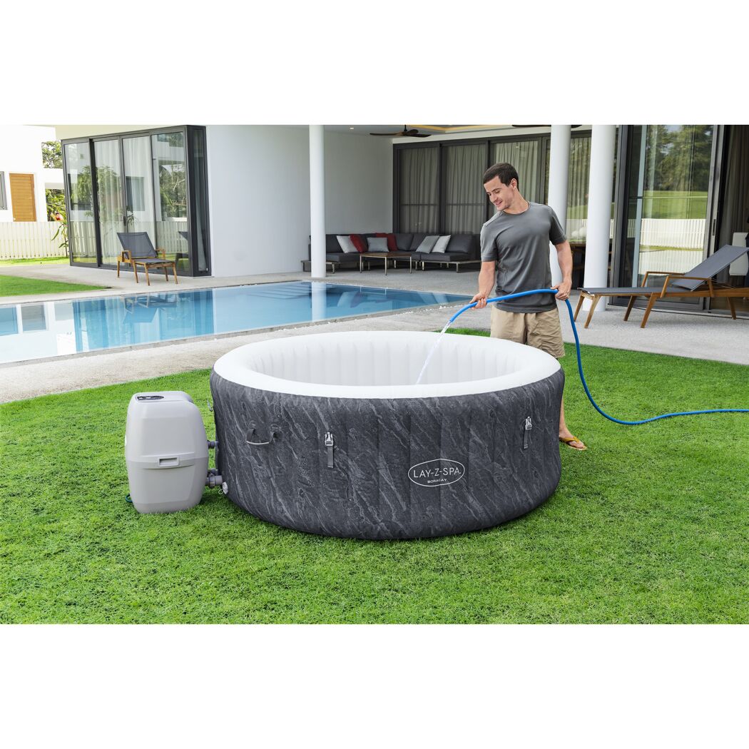 Person füllt einen LAY-Z-SPA Whirlpool mit einem Gartenschlauch.