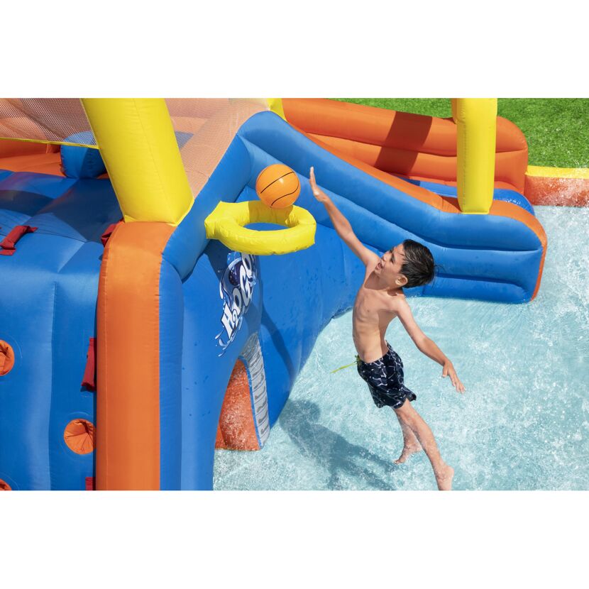 Kind wirft Basketball in aufblasbarem Wasserpark